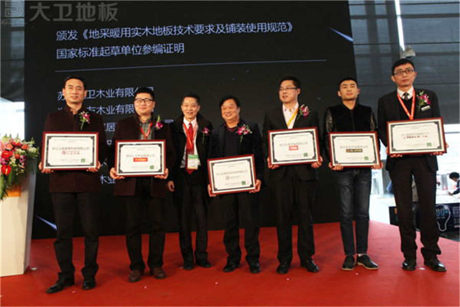 大衛(wèi)地板董事長(zhǎng)蔣衛(wèi)（左二）獲頒《地采暖用實(shí)木地板技術(shù)要求及鋪裝使用規(guī)范》國(guó)家標(biāo)準(zhǔn)起草單位參編證明.jpg